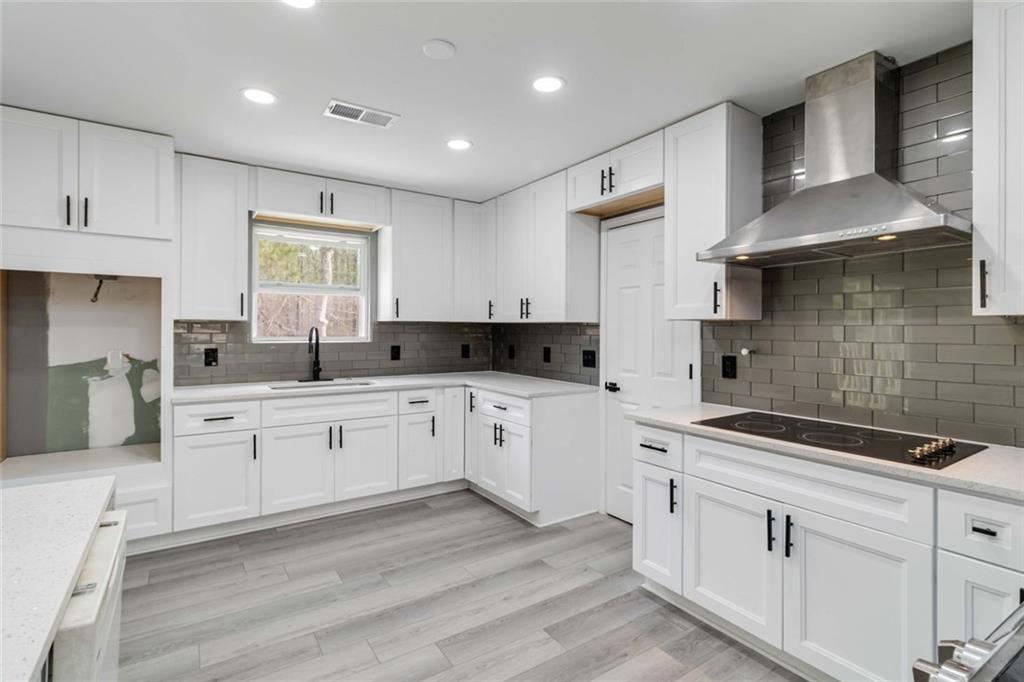 292 Natchez Circle Winder, GA 30680 - Photo 10 of 29 a kitchen with a sink dishwasher a stove and white cabinets