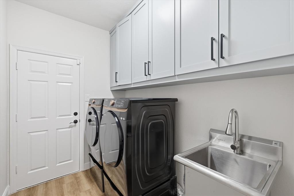 430 Ridgecrest Place Sanger, TX 76266 - Photo 27 of 40 Utility room featuring upper cabinetry with dark hardware, a stainless steel sink with a gooseneck faucet, and wood-finish flooring