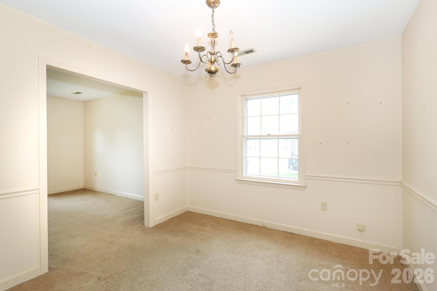 2000 Lawton Bluff Road Charlotte, NC 28226 - Photo 6 of 40 an empty room with chandelier fan and windows