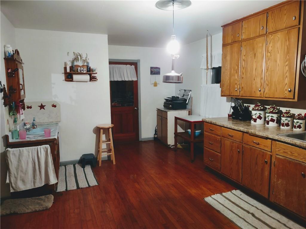 3325 Kennard Road Atlantic, PA 16111 - Photo 9 of 12 a kitchen with stainless steel appliances granite countertop a refrigerator a stove a sink and dishwasher with wooden floor