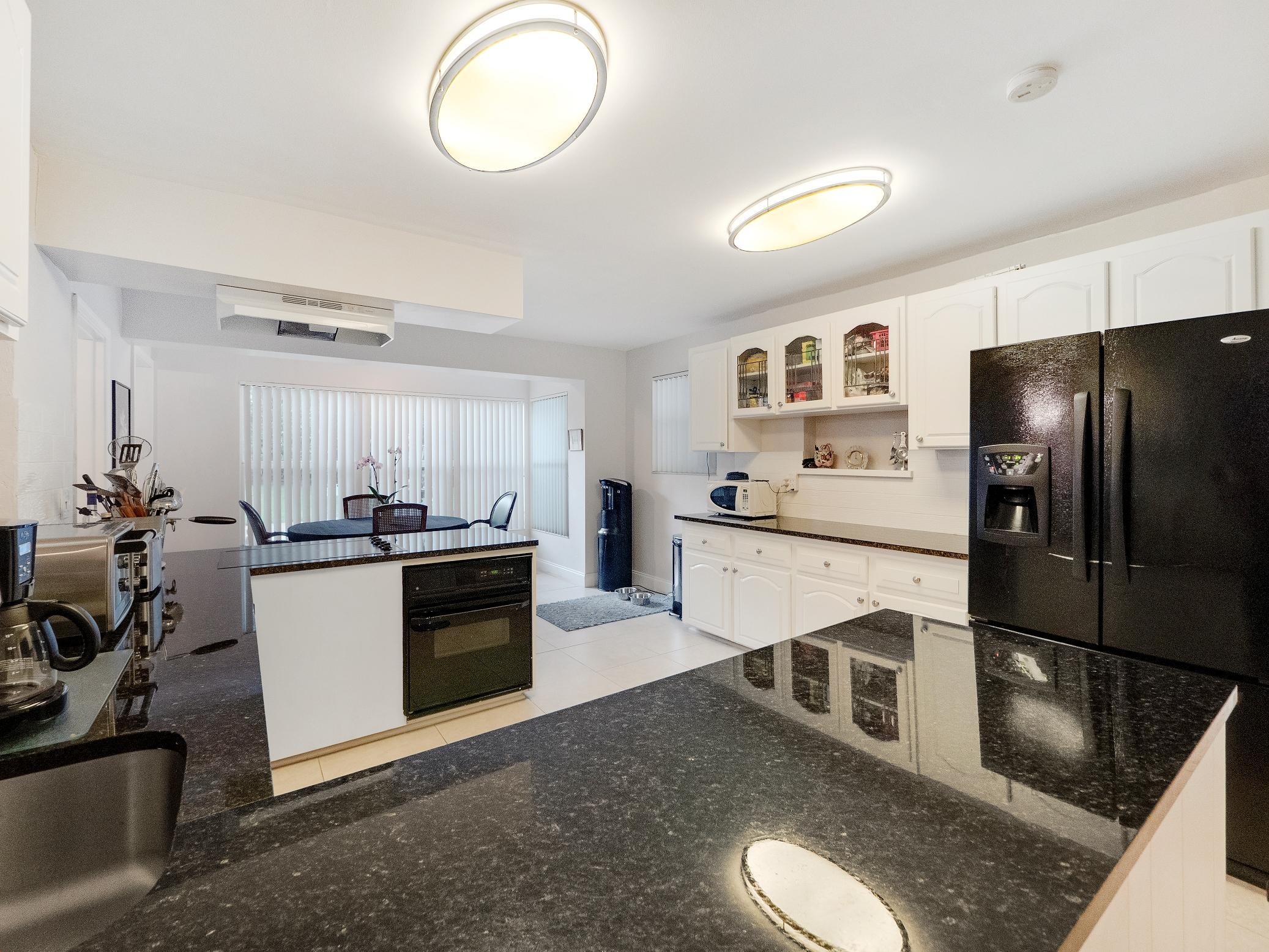 625 Atlantic Road North Palm Beach, FL 33408 - Photo 6 of 28 a kitchen with stainless steel appliances granite countertop a refrigerator sink and stove