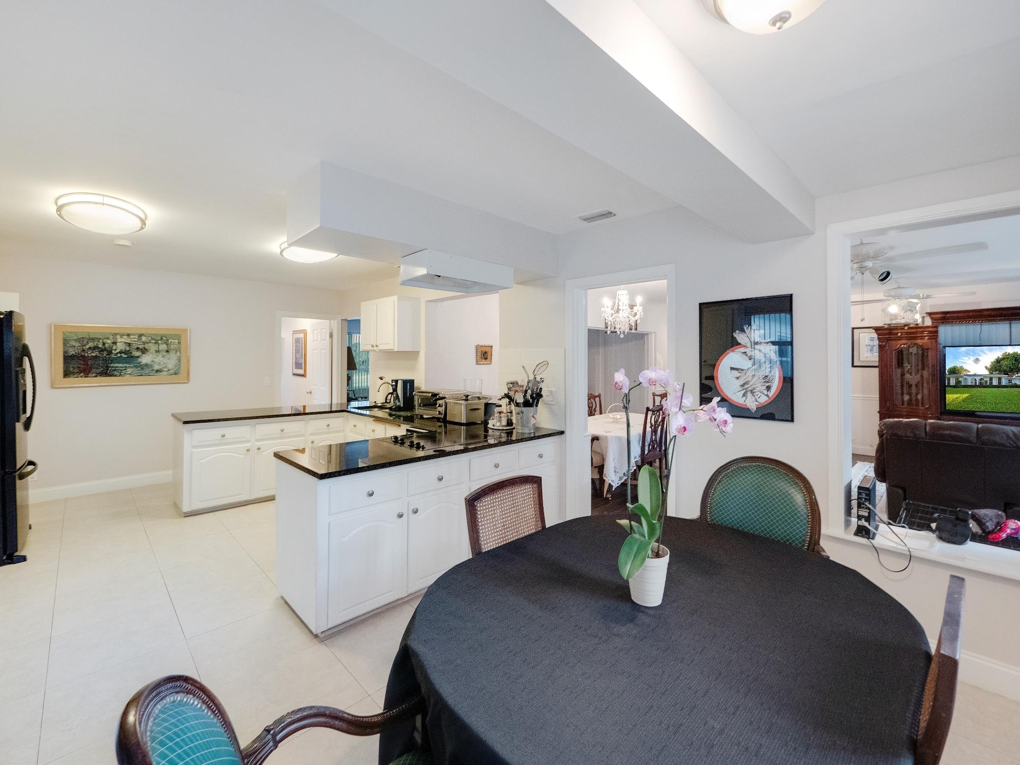 625 Atlantic Road North Palm Beach, FL 33408 - Photo 7 of 28 a kitchen with living room dining table wooden floor and a fireplace