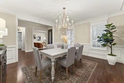 a kitchen with granite countertop a stove a sink and white cabinets