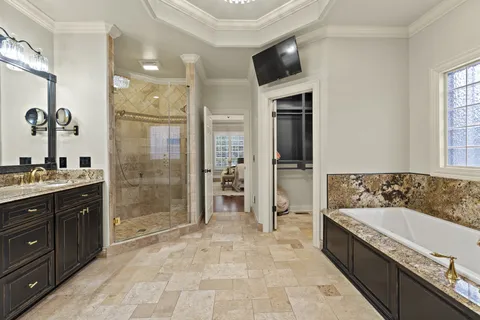 a spacious bathroom with a granite countertop sink a mirror and a shower