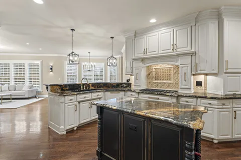 a kitchen with stainless steel appliances granite countertop a sink stove and cabinets