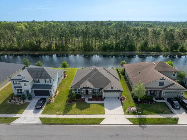an aerial view of a house with swimming pool and a garden