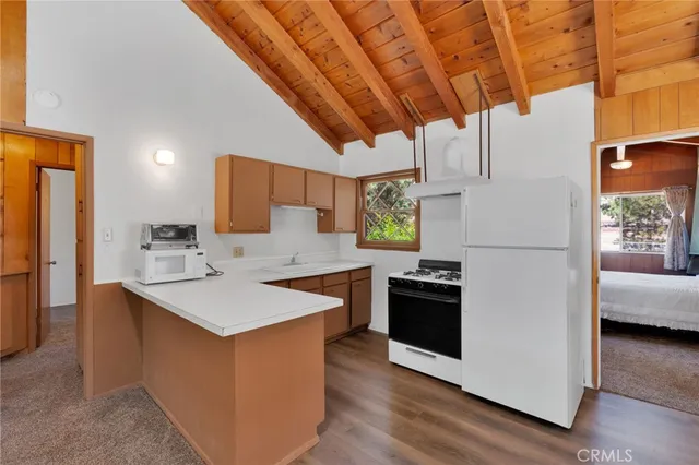 a kitchen with stainless steel appliances granite countertop a refrigerator a sink a stove and a refrigerator