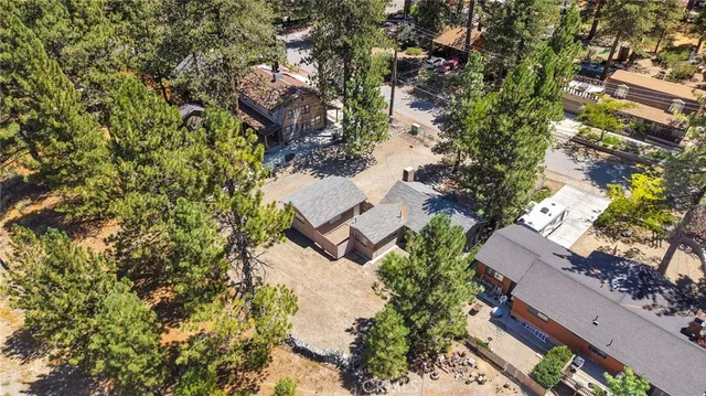 an aerial view of residential house with outdoor space and trees all around