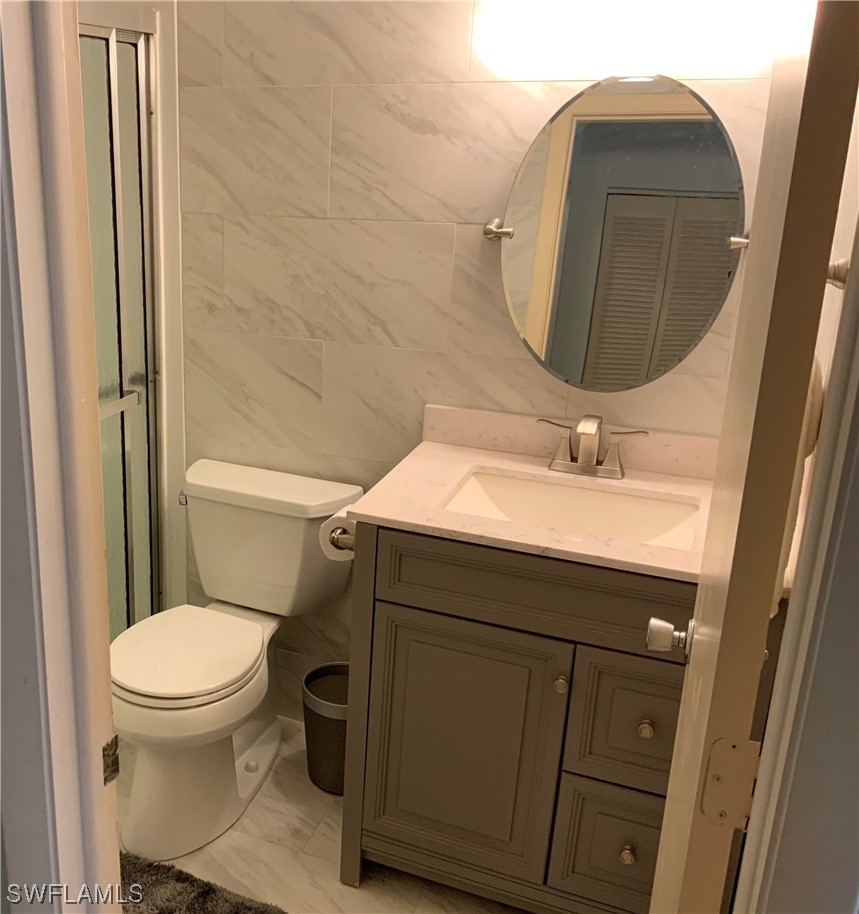 7055 New Post Road, Unit 5 North Fort Myers, FL 33917 - Photo 12 of 33 a bathroom with a sink toilet and mirror