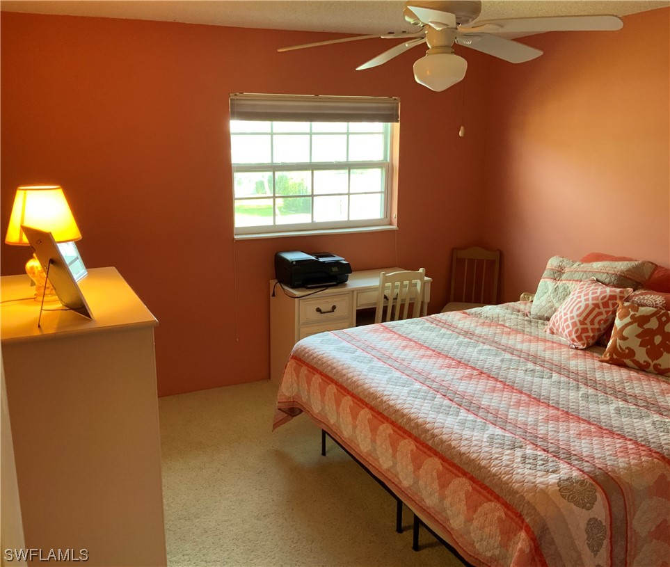 7055 New Post Road, Unit 5 North Fort Myers, FL 33917 - Photo 15 of 33 a bedroom with a bed and a chandelier