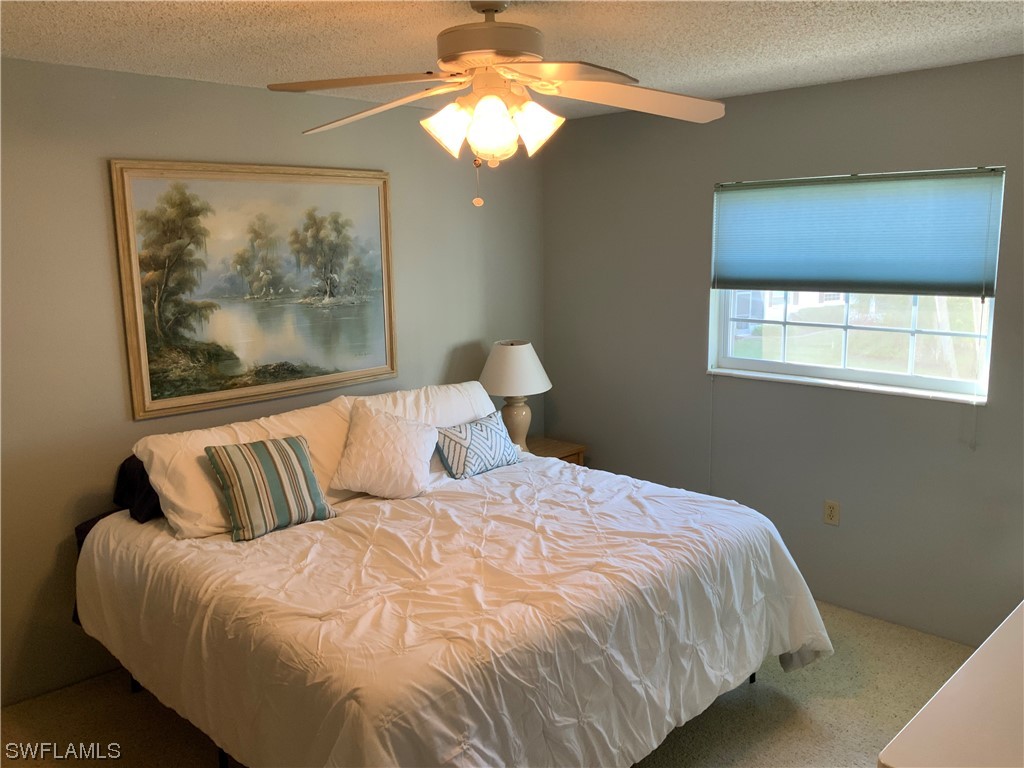 7055 New Post Road, Unit 5 North Fort Myers, FL 33917 - Photo 21 of 33 a bedroom with a bed and a painting on the wall