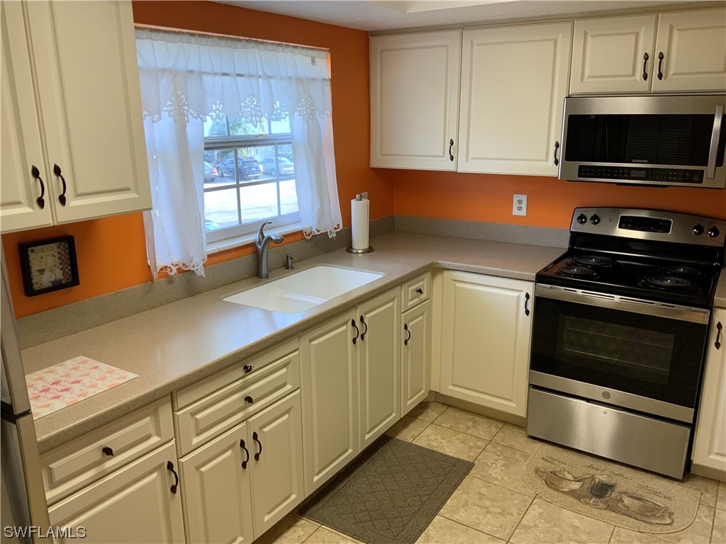 7055 New Post Road, Unit 5 North Fort Myers, FL 33917 - Photo 6 of 33 a kitchen with granite countertop a stove a sink and a microwave