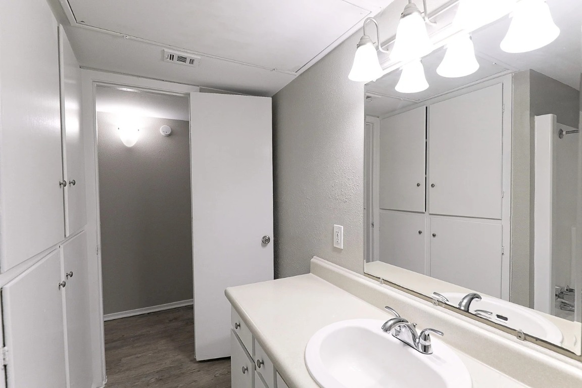 8100 North Mopac Expressway, Unit 2107 Austin, TX 78759 - Photo 18 of 23 Bathroom with vanity, a shower with curtain, light wood-type flooring, and a textured wall