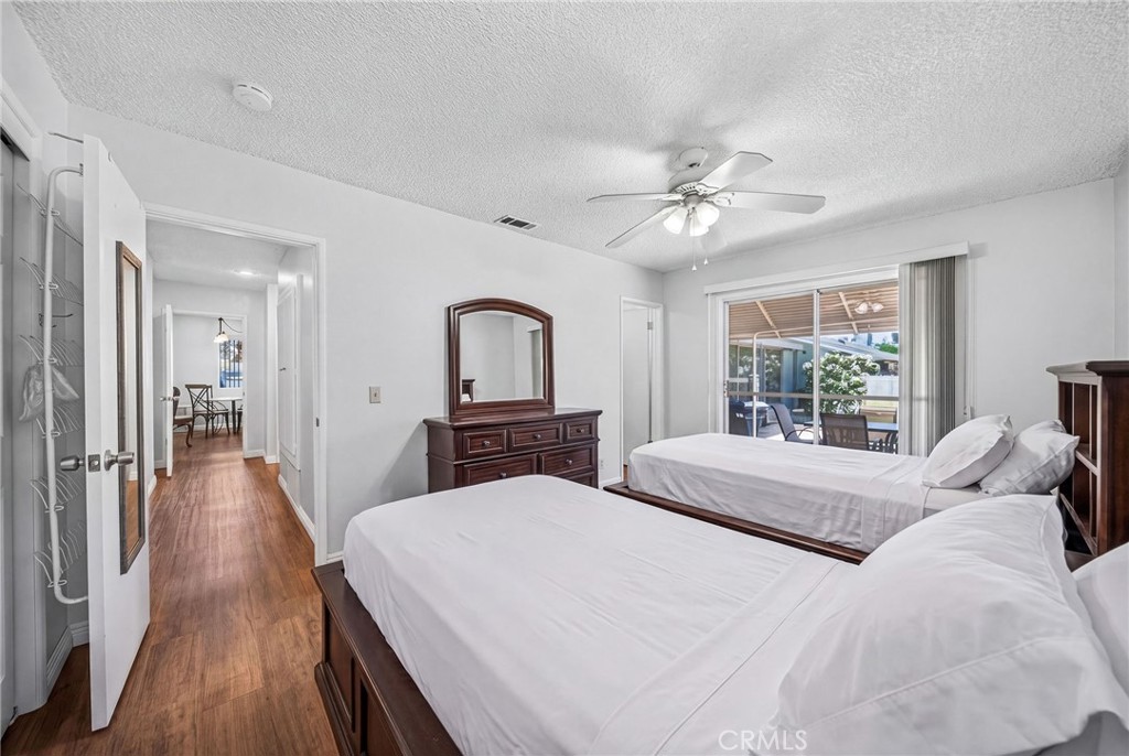 29078 Bradley Road Menifee, CA 92586 - Photo 26 of 42 a large bedroom with wooden floor and chandelier