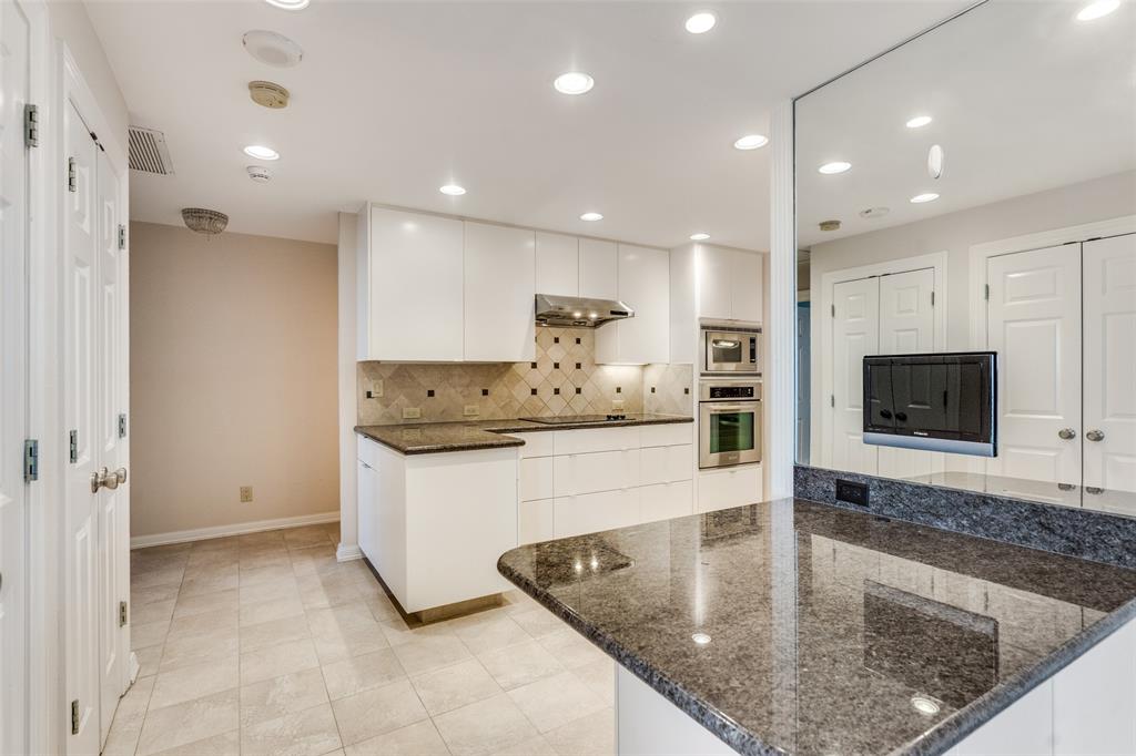 5200 Keller Springs Road, Unit 820 Dallas, TX 75248 - Photo 11 of 40 a large kitchen with kitchen island a large counter top stainless steel appliances and cabinets