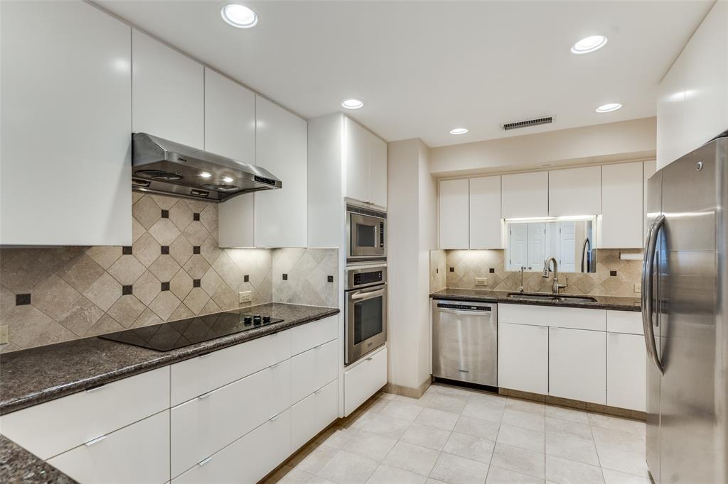 5200 Keller Springs Road, Unit 820 Dallas, TX 75248 - Photo 12 of 40 a kitchen with stainless steel appliances granite countertop a sink and a refrigerator