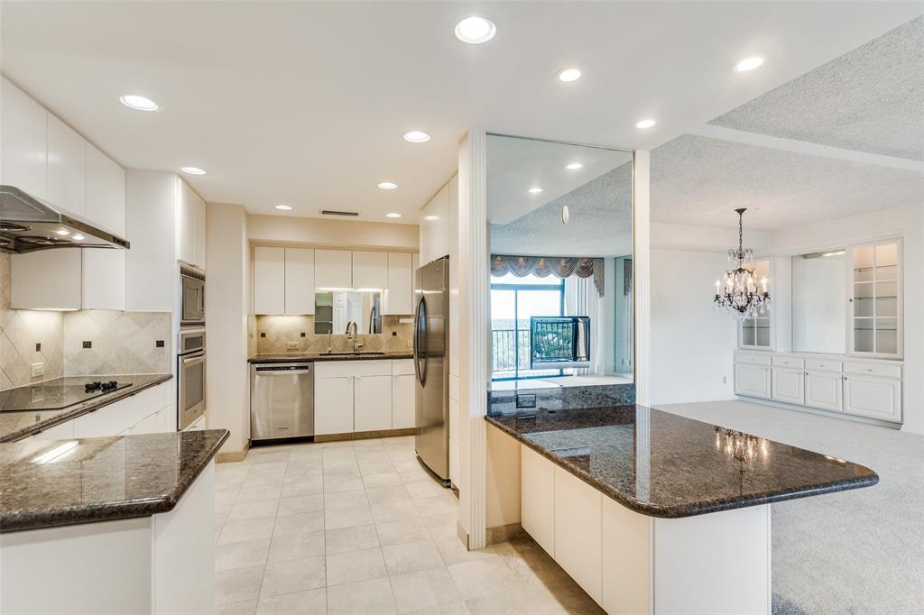 5200 Keller Springs Road, Unit 820 Dallas, TX 75248 - Photo 14 of 40 a large kitchen with stainless steel appliances kitchen island granite countertop a sink and cabinets