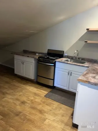 a kitchen with granite countertop a stove and a sink