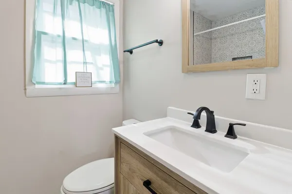 a bathroom with a sink a toilet and mirror