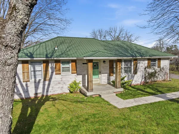a view of a house with backyard and sitting area