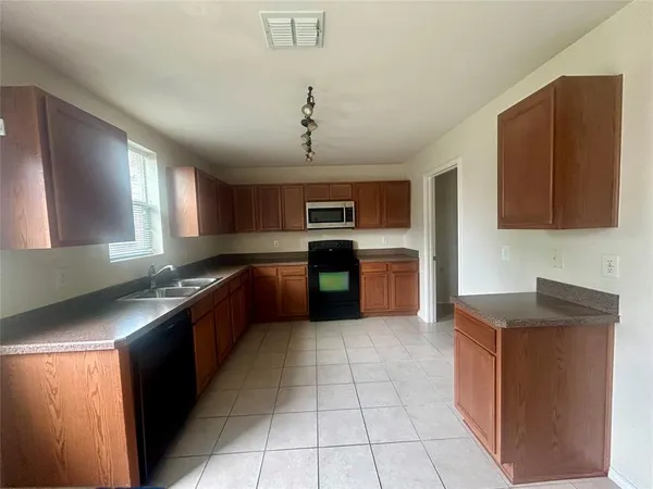a large kitchen with stainless steel appliances granite countertop a stove and a sink