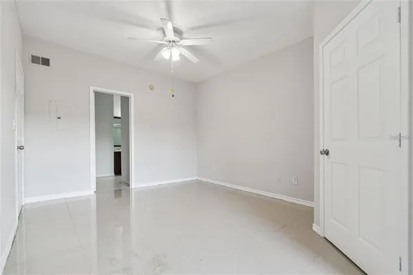 an empty room with a ceiling fan and carpet