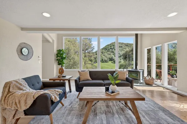 a living room with hardwood floor and a floor to ceiling window