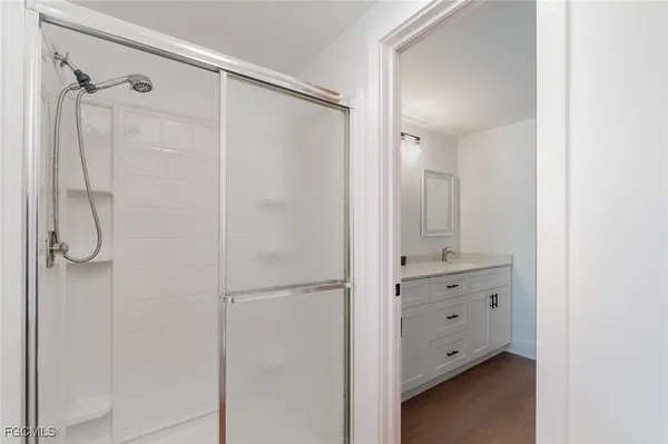 a bathroom with a shower sink and mirror