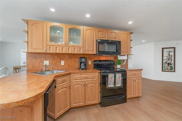 a kitchen with stainless steel appliances granite countertop a sink and a stove top oven