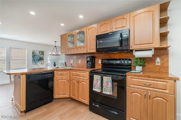 a kitchen with stainless steel appliances granite countertop a stove top oven a sink dishwasher and a microwave oven with cabinets