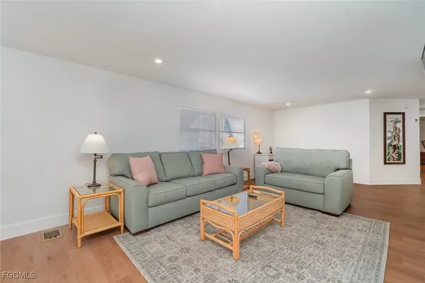 a living room with furniture a lamp and a rug