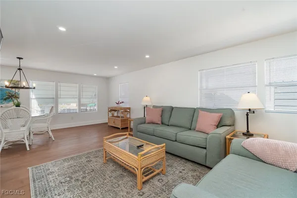 a living room with furniture a rug and a lamp