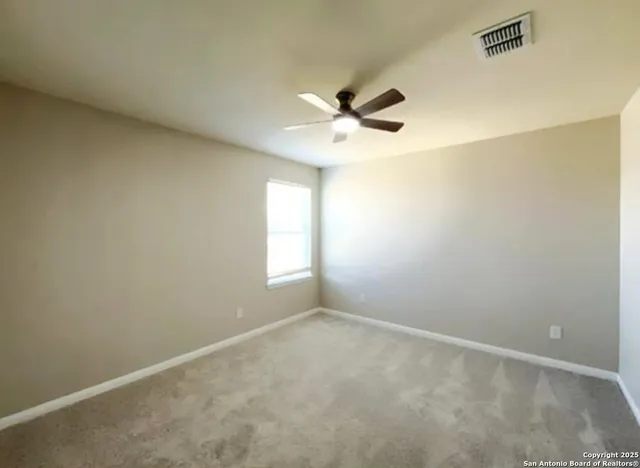 an empty room with a window and a fan