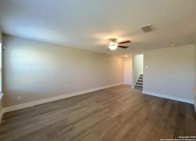 a view of an empty room with wooden floor