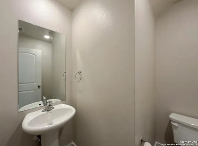 a bathroom with a sink a toilet and a mirror