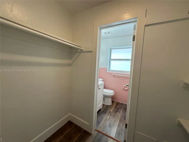 a bathroom with a granite countertop toilet and a sink