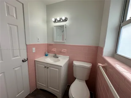 a bathroom with a toilet sink and mirror