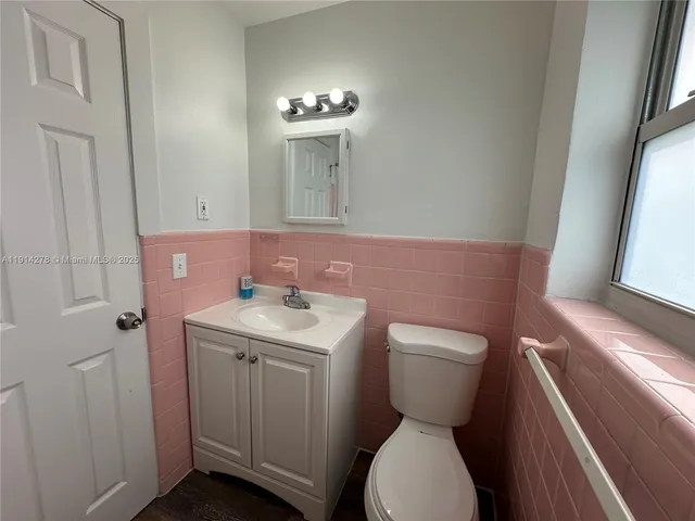 a bathroom with a toilet sink and mirror