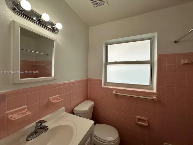 a bathroom with a sink mirror and toilet