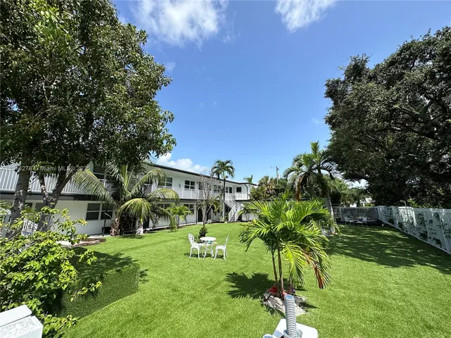 a view of backyard of house with green space