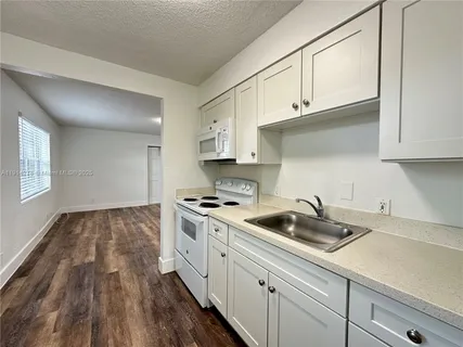 a kitchen with sink cabinets and stove top oven