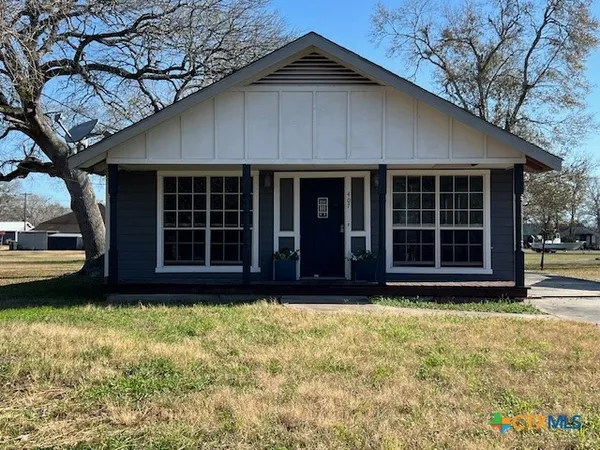 a view of a house with a large window and a yard