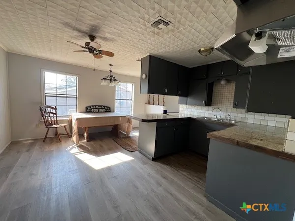 a kitchen with a sink dishwasher a stove and a refrigerator with wooden floor