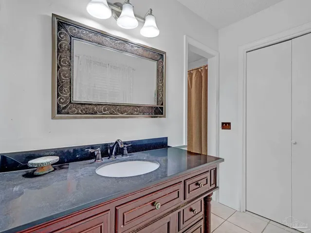 a bathroom with a granite countertop sink a mirror and a vanity
