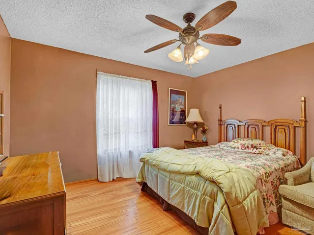 a bed sitting in a spacious bedroom next to a window