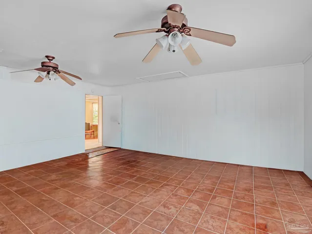 a view of an empty room and window with a chandelier fan