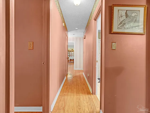 a view of a hallway with wooden floor and stairs