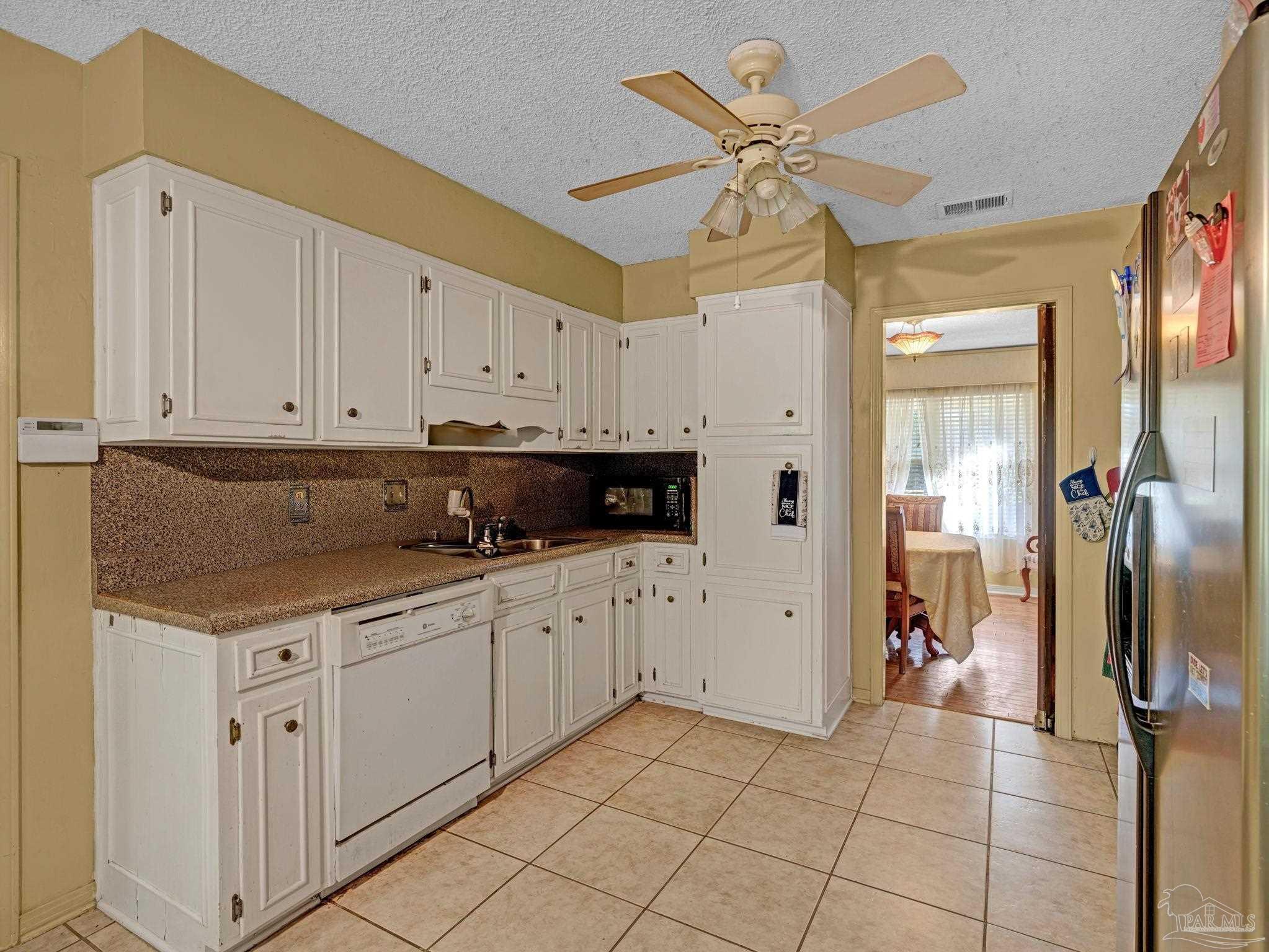 4112 Croydon Road Pensacola, FL 32514 - Photo 7 of 25 a kitchen with stainless steel appliances granite countertop a refrigerator a sink and white cabinets