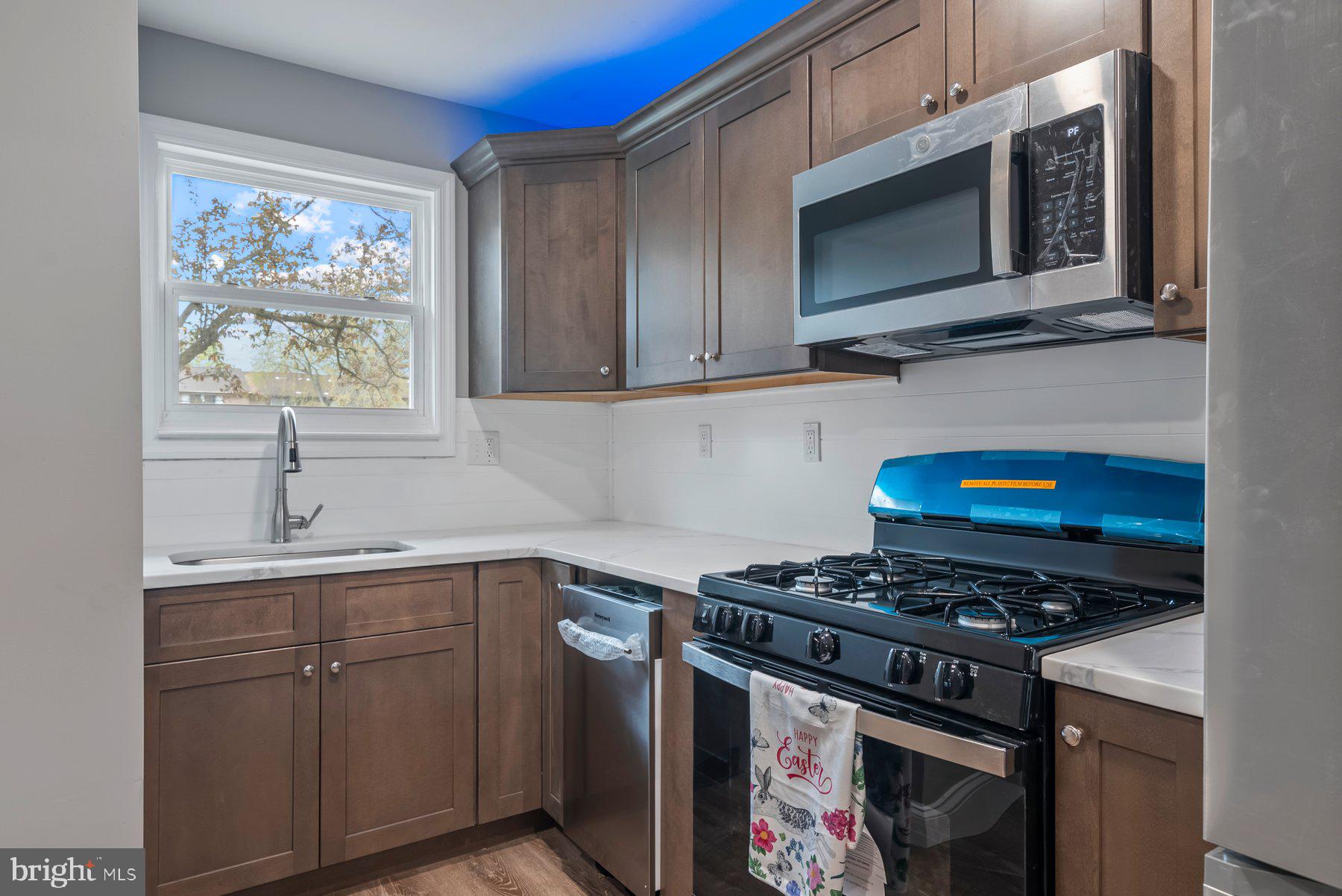 261 Via Cascata Drive Clementon, NJ 08021 - Photo 7 of 26 a kitchen with stainless steel appliances a stove microwave and sink