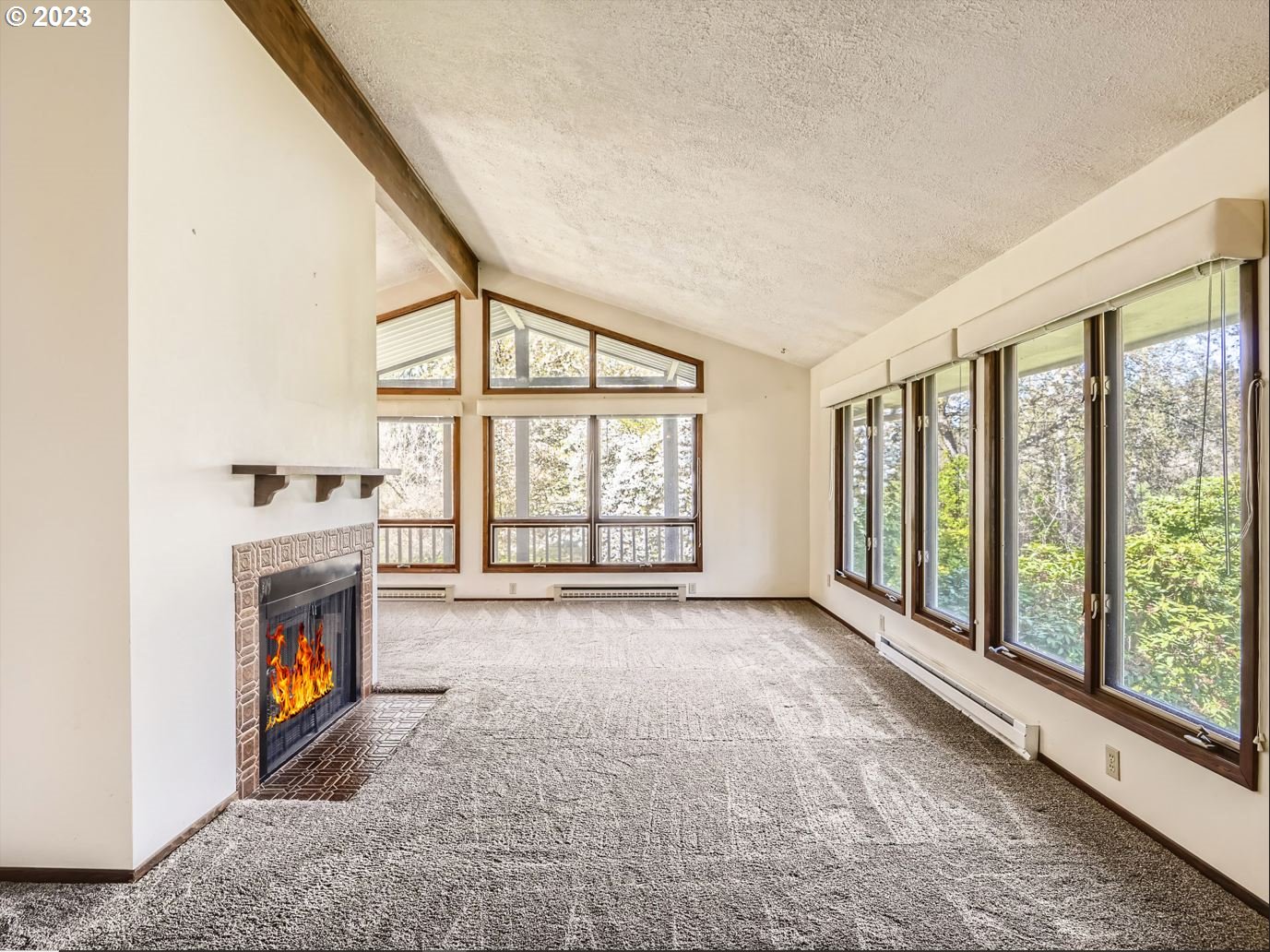 18331 Northwest Reeder Road Portland, OR 97231 - Photo 13 of 46 a view of an empty room with a fireplace and a window